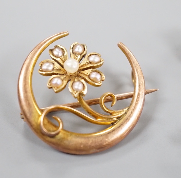 A late Victorian 15ct and seed pearl set flower and crescent brooch, 22mm, gross 3.1 grams and two later yellow metal bar brooches, gross 6 grams.